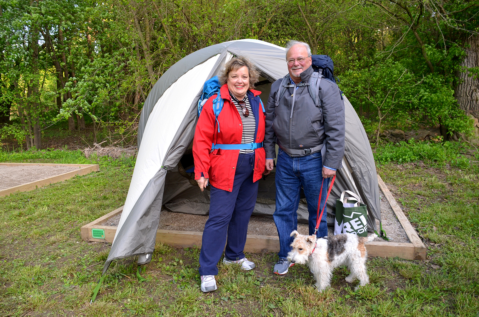Couple and dog outside their backpacking tent