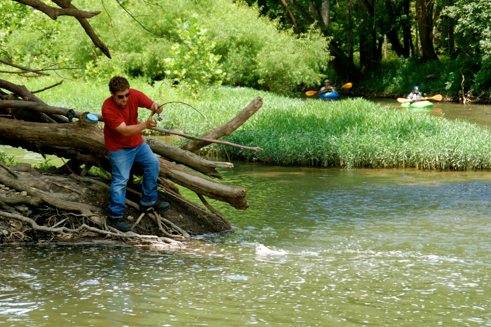 Man catches a fish from banks of Big Darby Creek in Battelle Darby Creek Metro Park.
