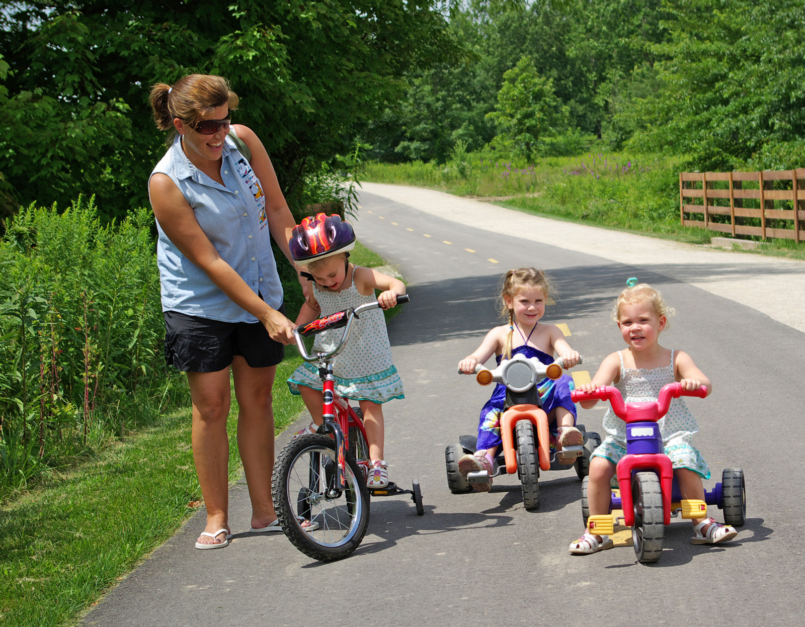 Three young tricyclists with adult supervision on the Multi-use Trail at Blacklick Woods.