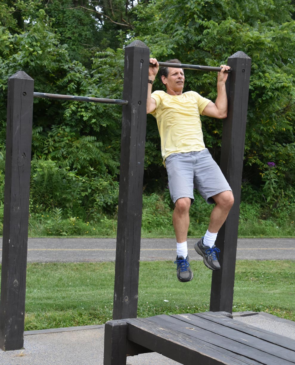 A man uses the pull-up bars at Sharon Woods' fitness station.