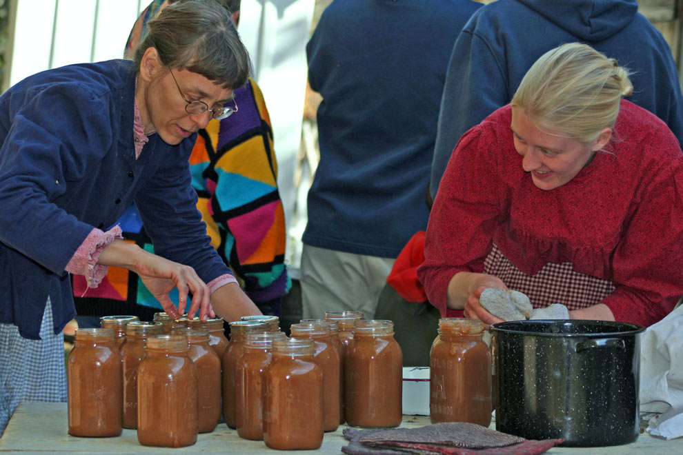 Staff at Slate Run Living Historical Farm seal mutliple jars of apple butter made on the farm the way it was made in the 1880s.