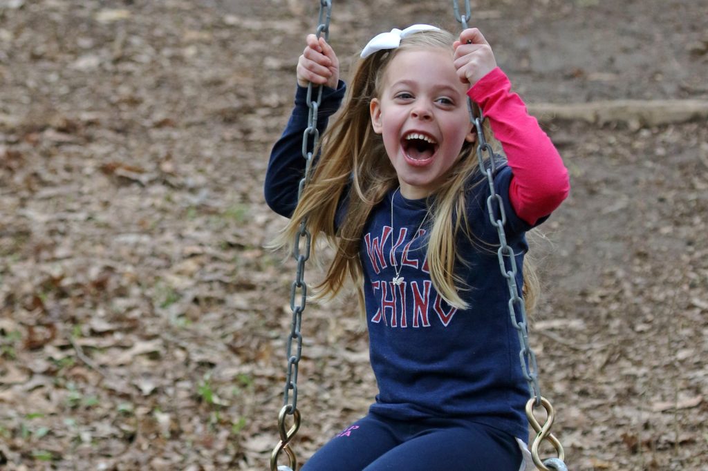 Child on swing at Blendon Woods natural play area.