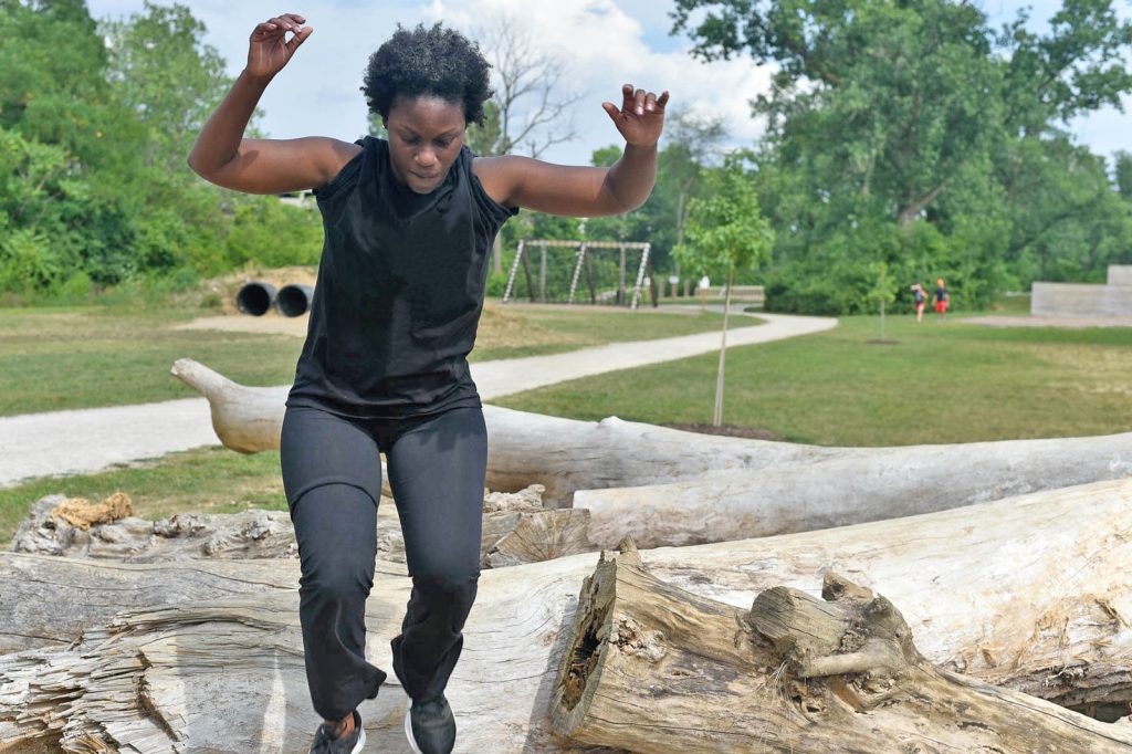Woman on the log run on the obstacle course at Scioto Audubon