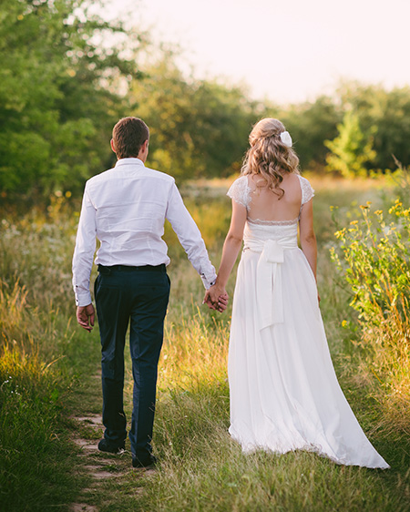 Fashionable, beautiful young couple holding hands and walking in