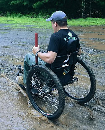 Man using GRIT accessibility chair in wet muddy area